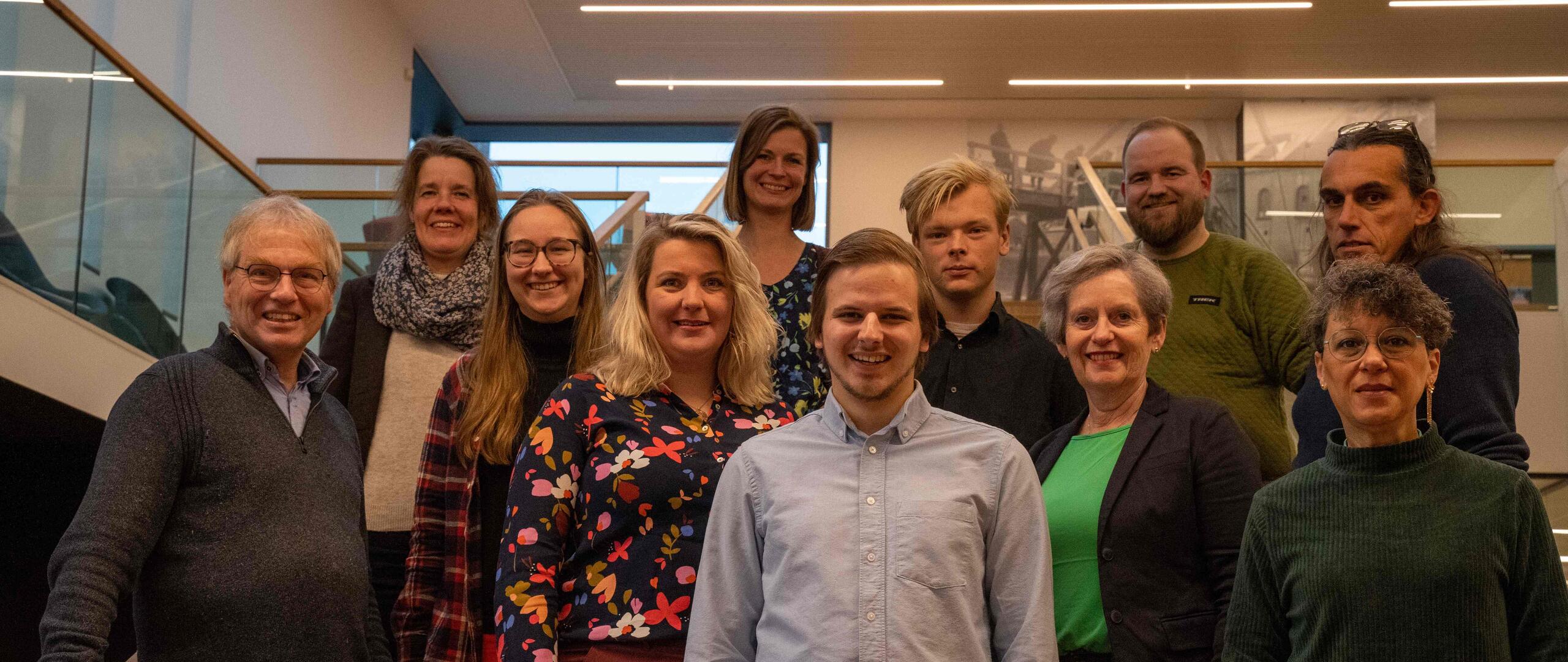 Ons team kandidaten staat op een trap en lacht richting de camera.