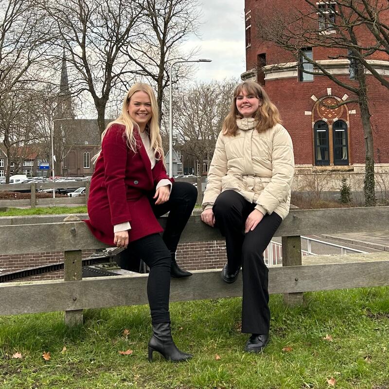 Esmee Pater en Aniek Wierstra leunen op een houten hek